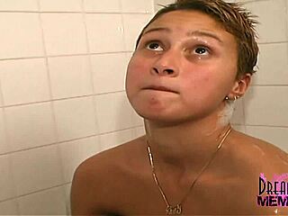 Sexy short-haired brunette shaves her legs in a steamy shower