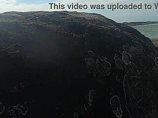 Uma linda novinha é observada fazendo sexo em público nas pedras da praia e é atrapalhado por um terceiro indivíduo