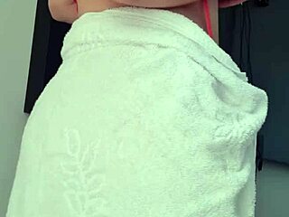 Blonde slut shows off her big ass in towel at window.