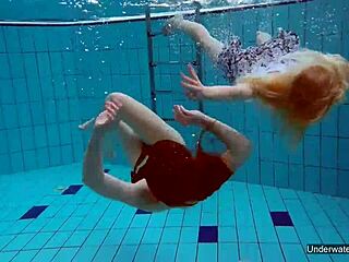 Two hot shaved lesbians kiss and touch underwater in pool