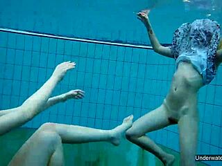 Two hot shaved lesbians kiss and touch underwater in pool