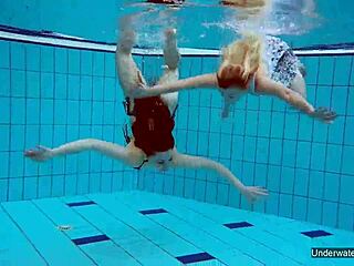 Two hot shaved lesbians kiss and touch underwater in pool