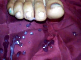 Ebony beauty delivers a teasing footjob leading to cumshot