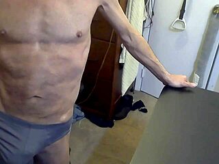 Grinding on stool and football in grey briefs for muscle tension release